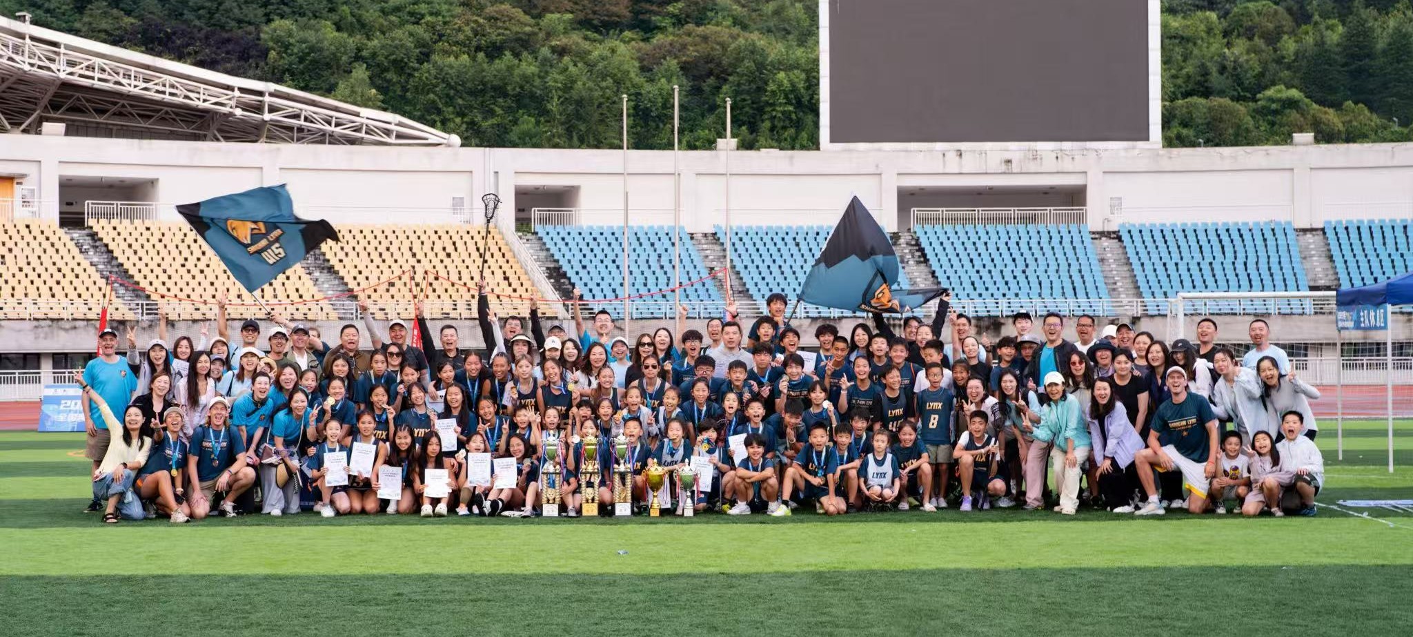 Shanghai Lynx players, coaches, and families celebrating with trophies after a tournament